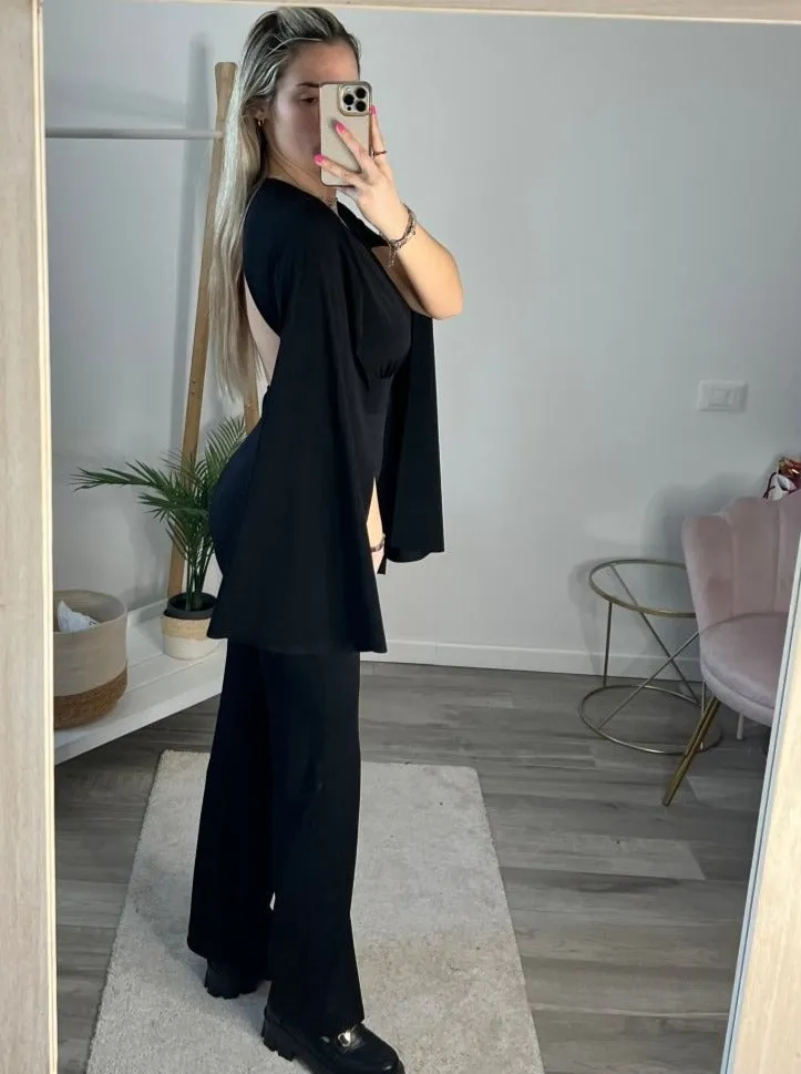 Jumpsuit nera con maniche a mantella con spacco