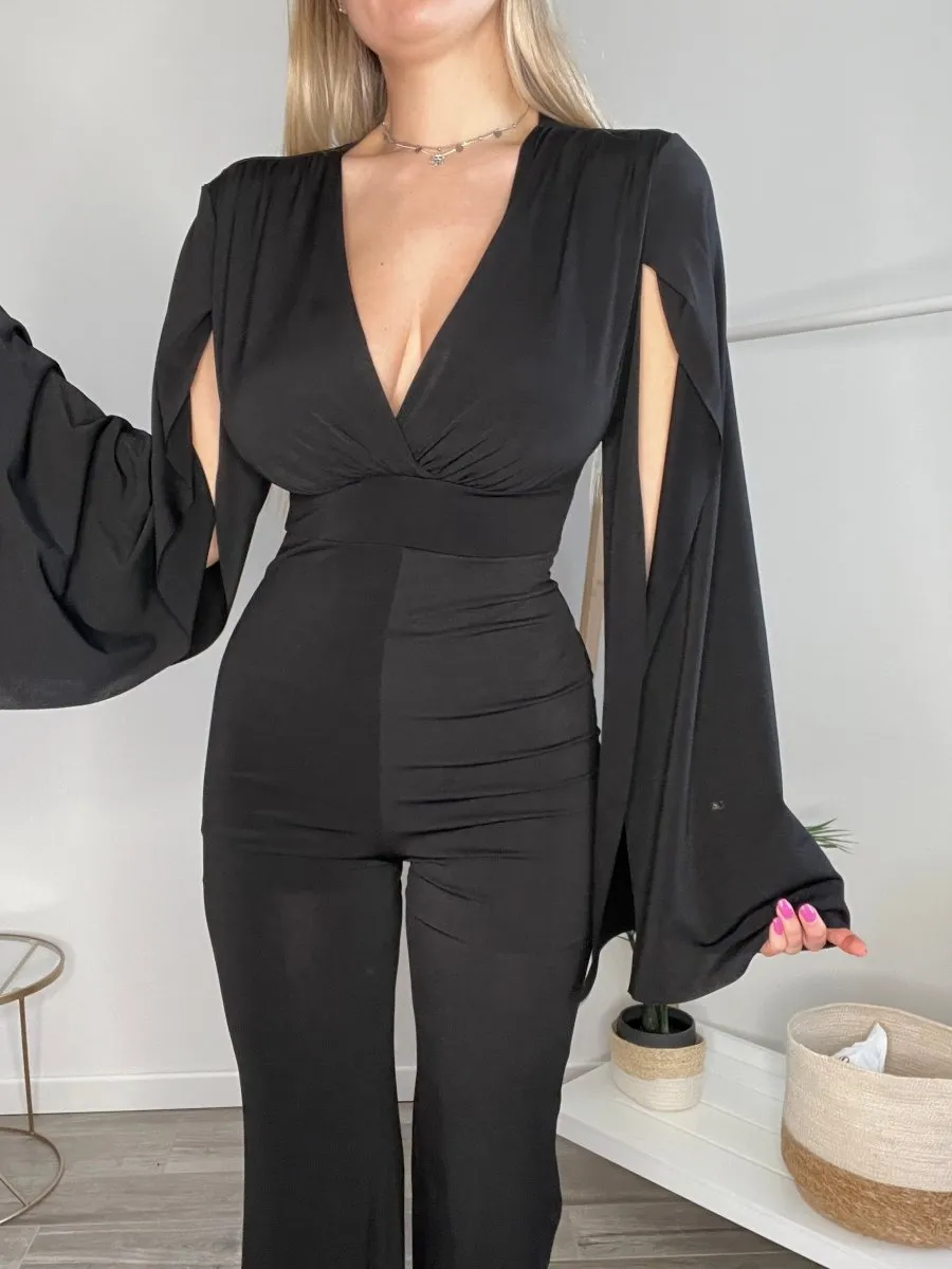 Jumpsuit nera con maniche a mantella con spacco