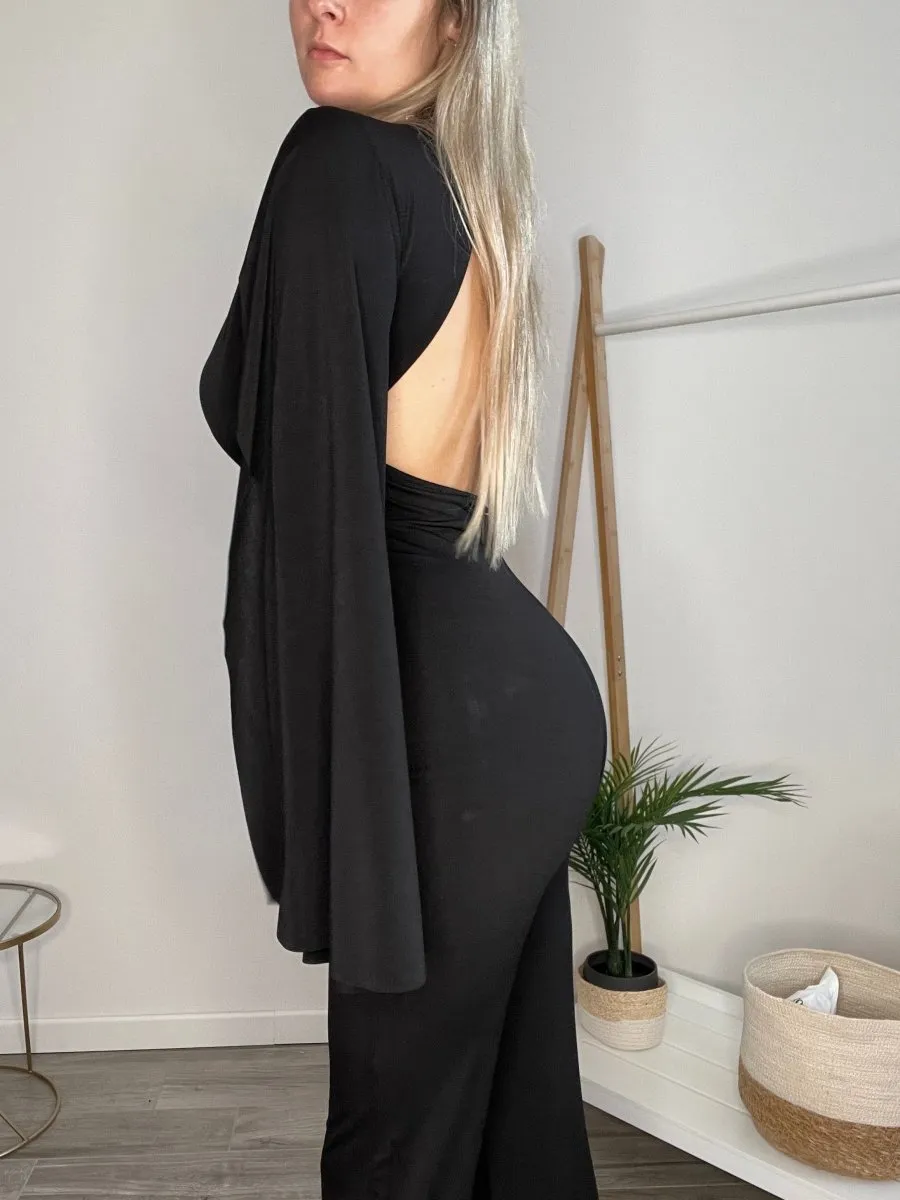 Jumpsuit nera con maniche a mantella con spacco